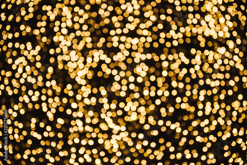 Abstract gold bokeh with dark background.