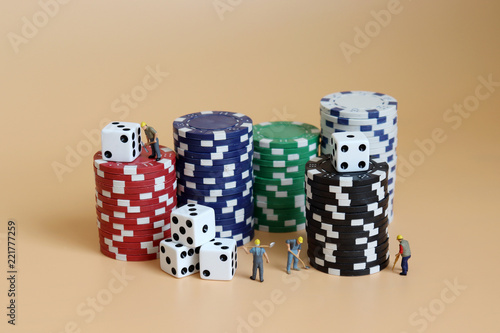 Miniature workers with stacks of casinos chips and dice. photo