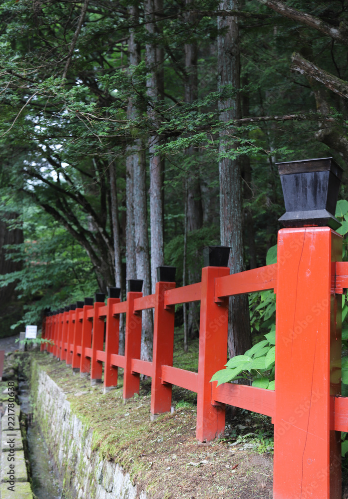 Closeup of red wooden fence in the park with natural background. Vertical view. Closeup of red wooden fence in the park with natural background. Vertical view.