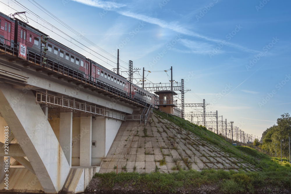 Russia, Moscow August 2018: passenger train is traveling along the railway bridge over the river.