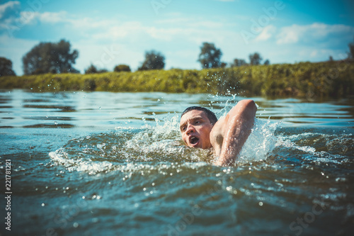 The young man swimming in the river