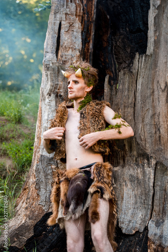 Portrait of handsome man with crown in forest. Prince of elves. Noble fairy elf in the magic forest. Fantasy. Fairy tale.