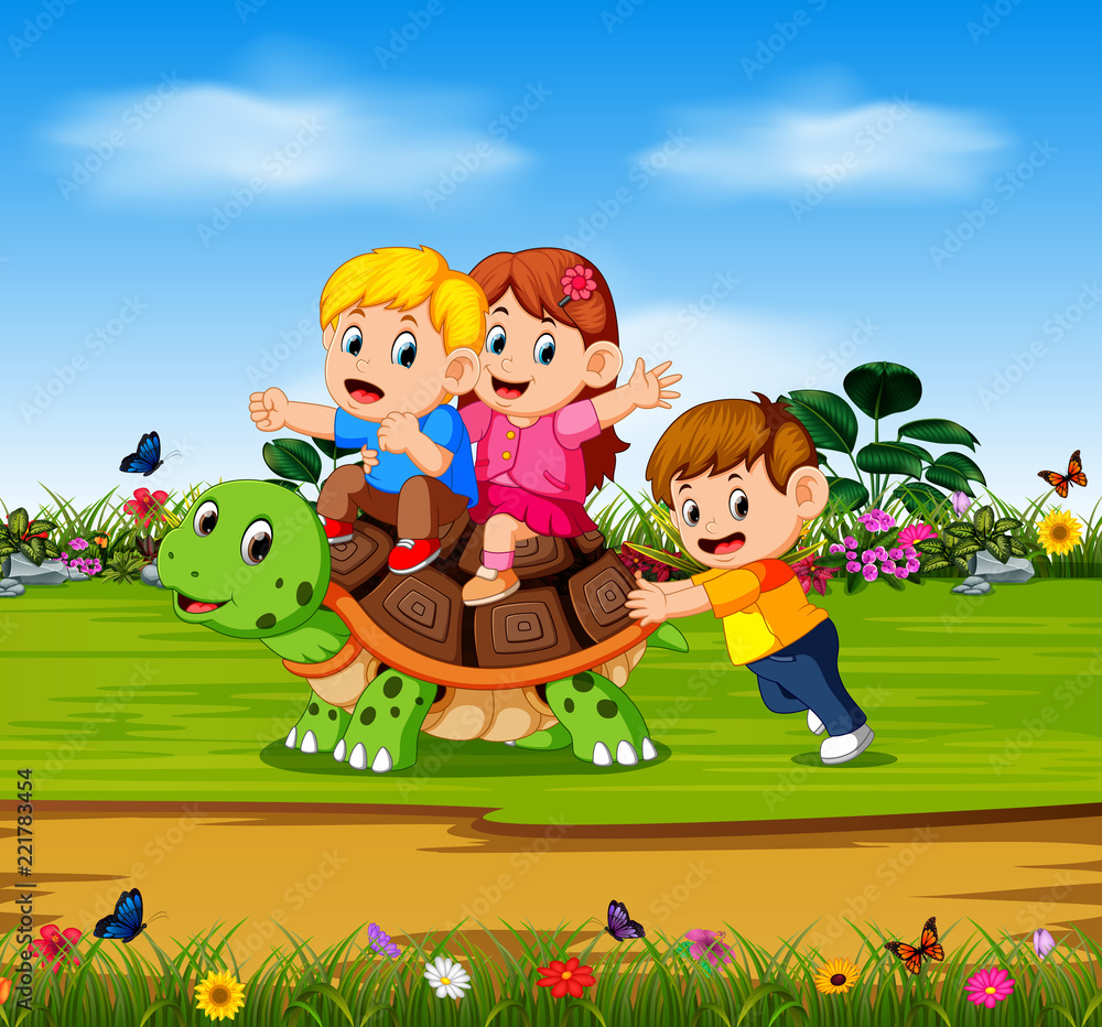 the three children are playing on the big turtle in the forest
