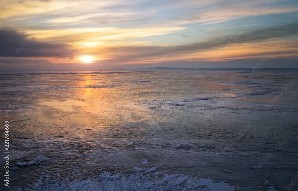 Obraz premium Beautiful colorful winter landscape with frozen lake and sunset sky.