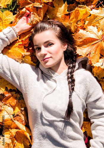 the girl lies on the autumn leaves