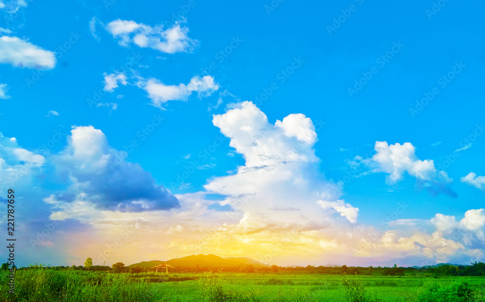 Beautiful view of evening landscape green meadow with blue sky and dramatic sunset in the mountains. Environment concept. Nature summer background