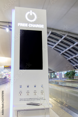 Free battery charging station in the airport for traveler. Phone charging on a table at charging station in the lobby. Free charging on the airport terminal.