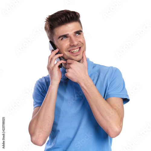 happy casual man is dreaming while talking on the phone