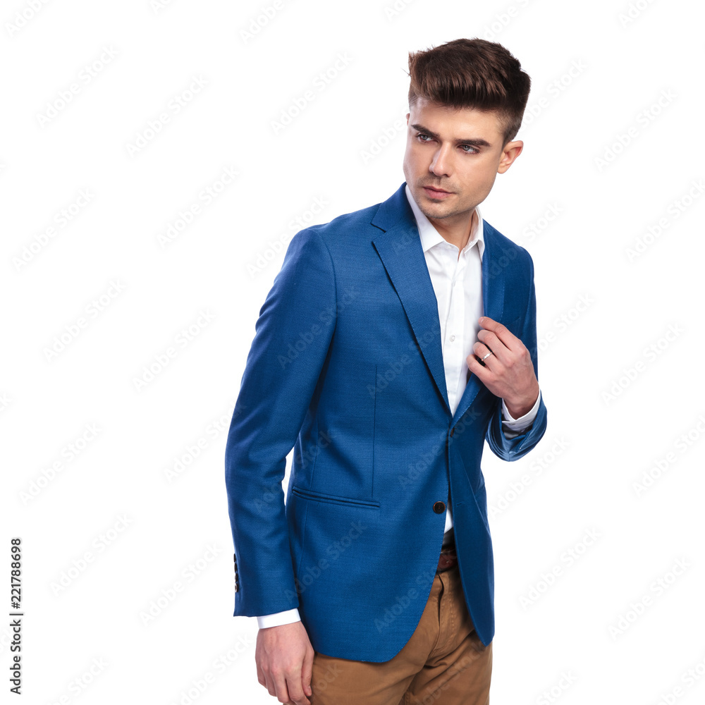 young handsome man looks back and holds collar young handsome man looks back and holds collar