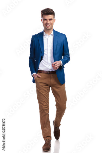 relaxed young smart casual man walking forward photo