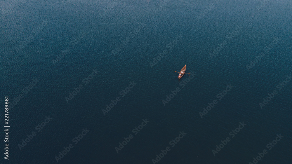Aerial view of the boat in the lake. Summer. Day. People in the boat are swimming on the lake.