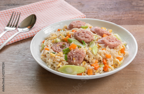 close up of fried rice with fermented pork sausage in a ceramic dish on wooden table. asian homemade style food concept.