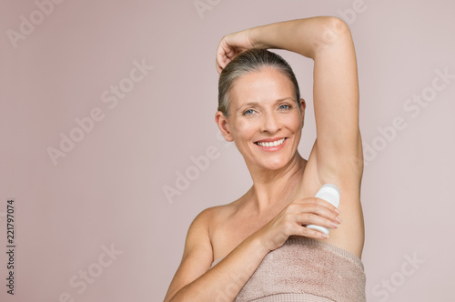 Mature woman using deodorant stick