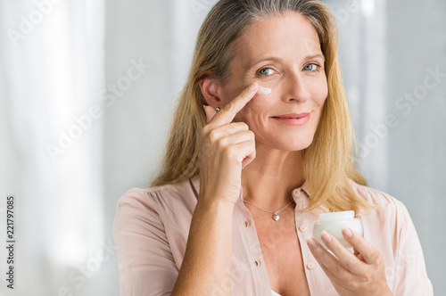 Woman applying anti aging lotion on face
