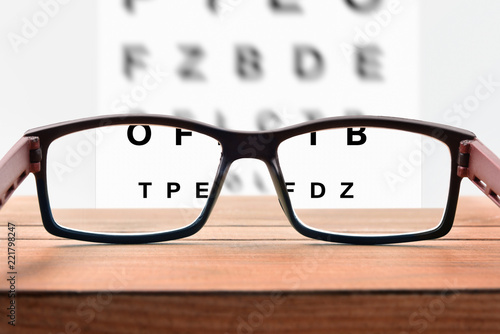 Glasses on table and alphabet letter front view photo