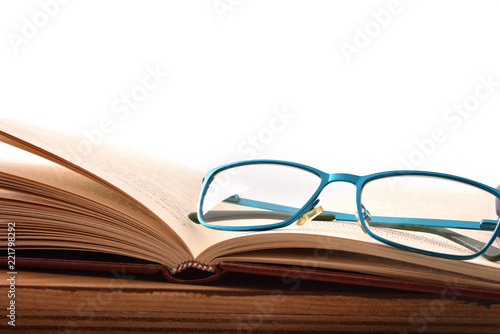 Reading glasses on wood table with open book front