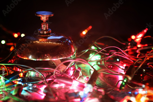 reception bell on table and color shining garland on background