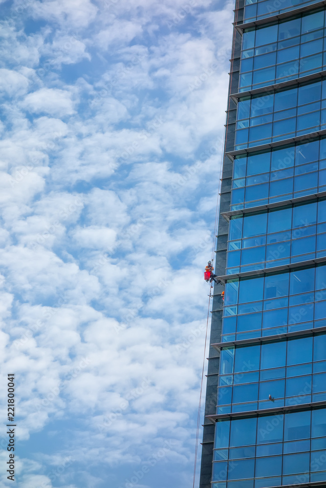 Window cleaning of skyscraper with rope. Specialized jobs at risk Window cleaning of skyscraper with rope. Specialized jobs at risk