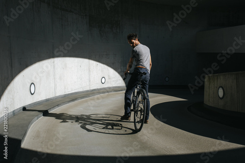 Rückansicht von männlichem Radfahrer, der in einer urbanen Landschaft auf seinem Fahrrad fährt