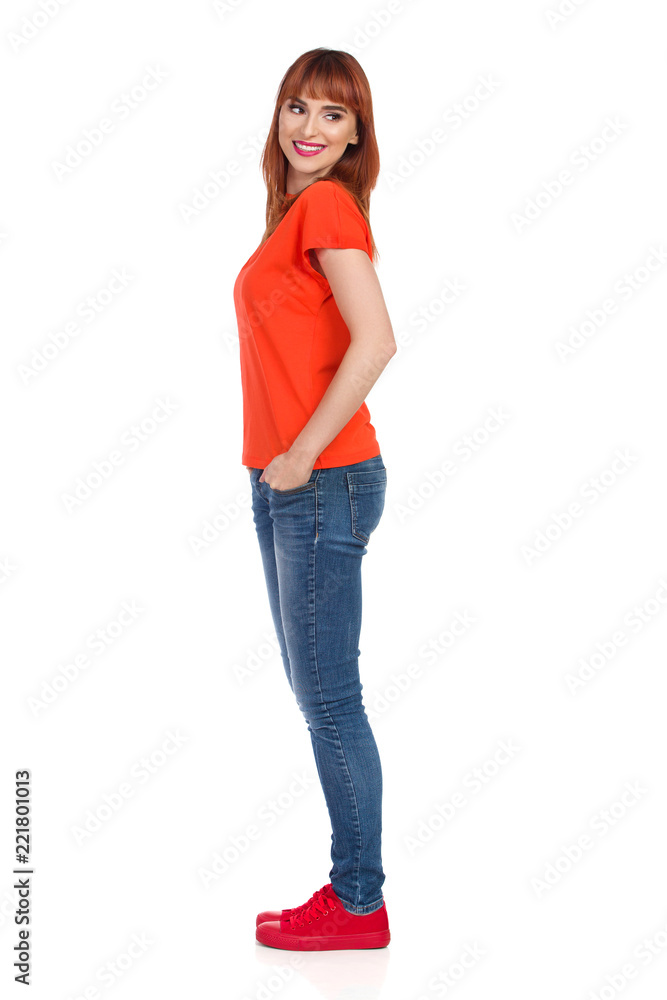 Young Woman Is Standing, Smiling And Looking Over Shoulder. Side View. Young Woman Is Standing, Smiling And Looking Over Shoulder. Side View.