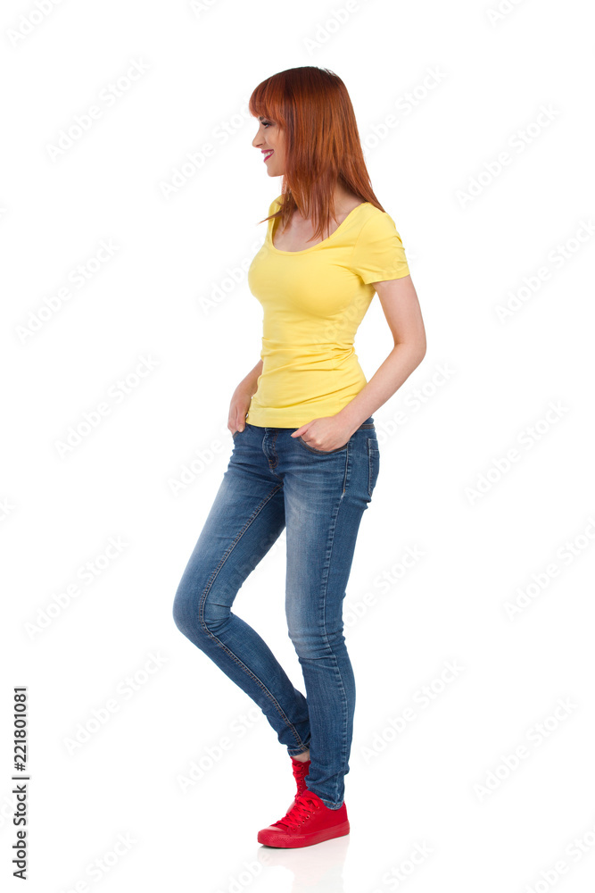 Side View Of Smiling Casual Young Woman Standing And Looking Away Side View Of Smiling Casual Young Woman Standing And Looking Away