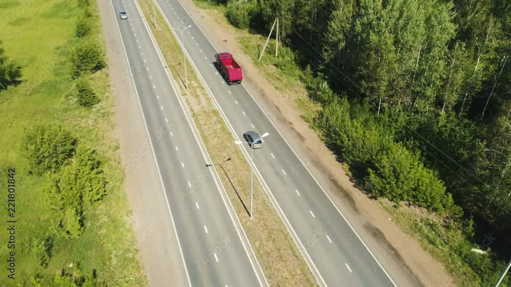 red lorry moves along highway to distant city on horizon red lorry moves along highway to distant city on horizon