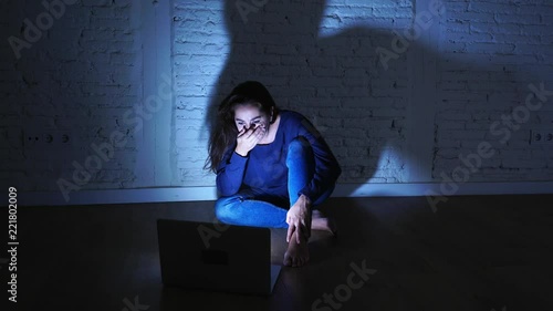 Sad and scared female Young woman with computer laptop suffering cyberbullying and harassment being online abused by stalker or gossip feeling desperate and humiliated in cyber bullying concept.