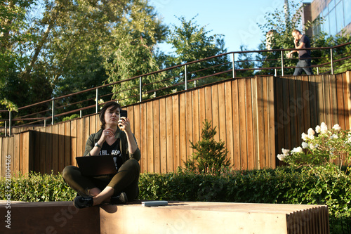 Young woman working in a quiet courtyard of an office building photo