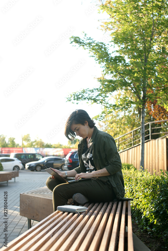 Young woman working in a quiet courtyard of an office building Young woman working in a quiet courtyard of an office building