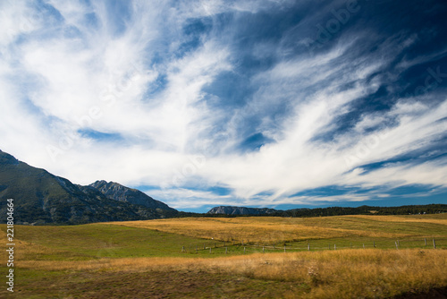 field and mountains against the backdrop of a bright sky