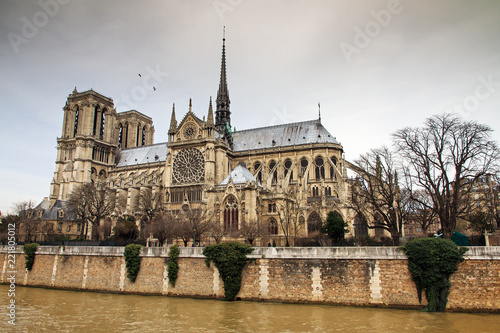 Side view of the Notre-Dame Cathedral in Paris with a moody sky