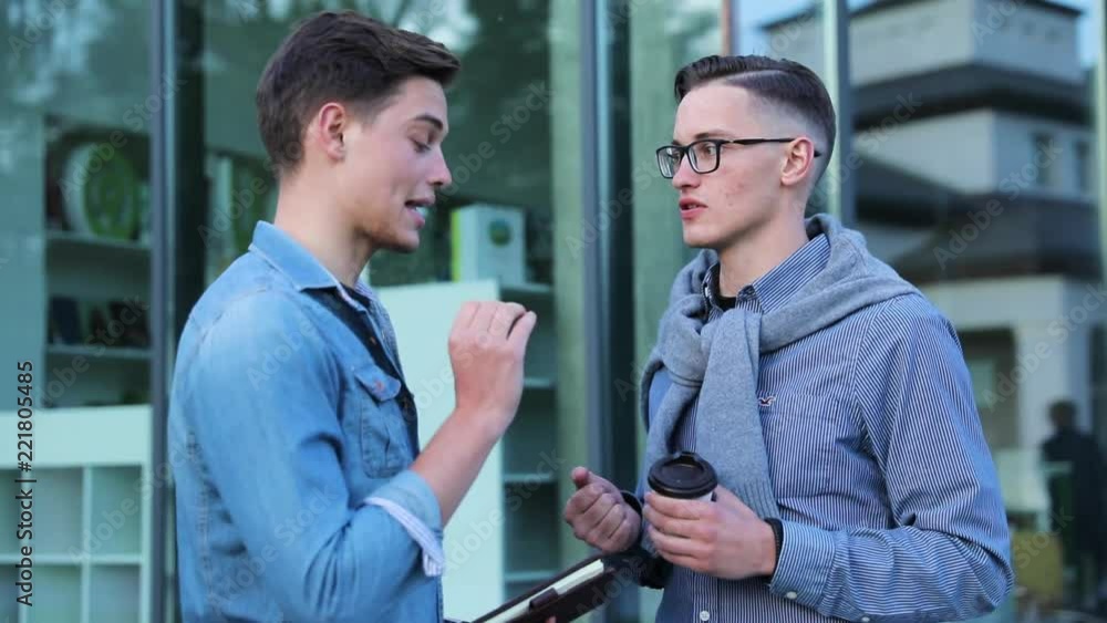 Young Men Talking Near Office Building Outdoors Young Men Talking Near Office Building Outdoors
