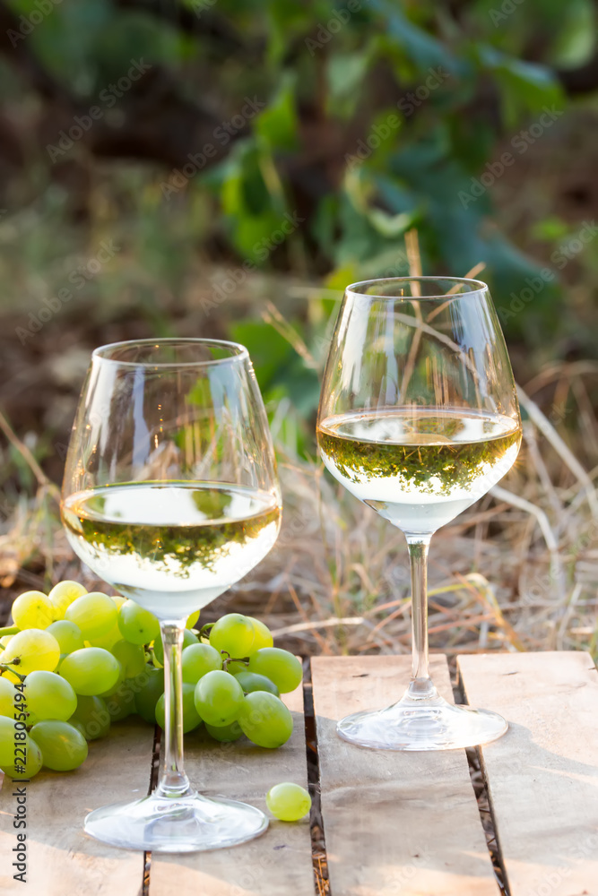 two glasses of white wine on a wooden background two glasses of white wine on a wooden background