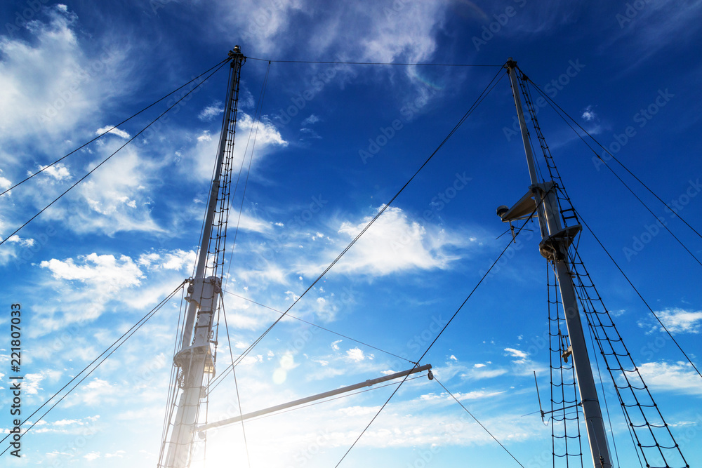 Two masts of a ship against the blue sky Two masts of a ship against the blue sky