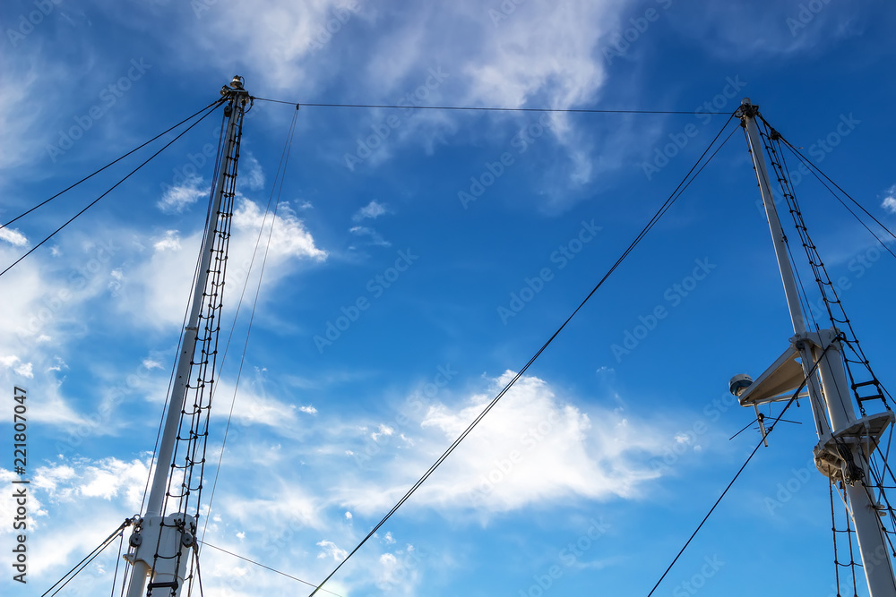 Two masts of a ship against the blue sky