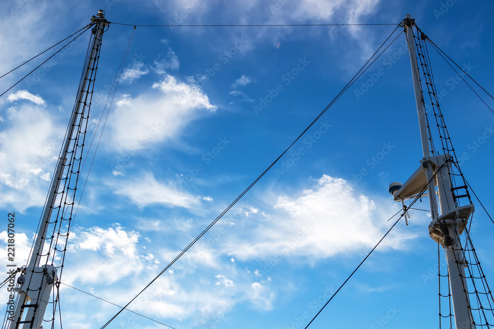 Two masts of a ship against the blue sky