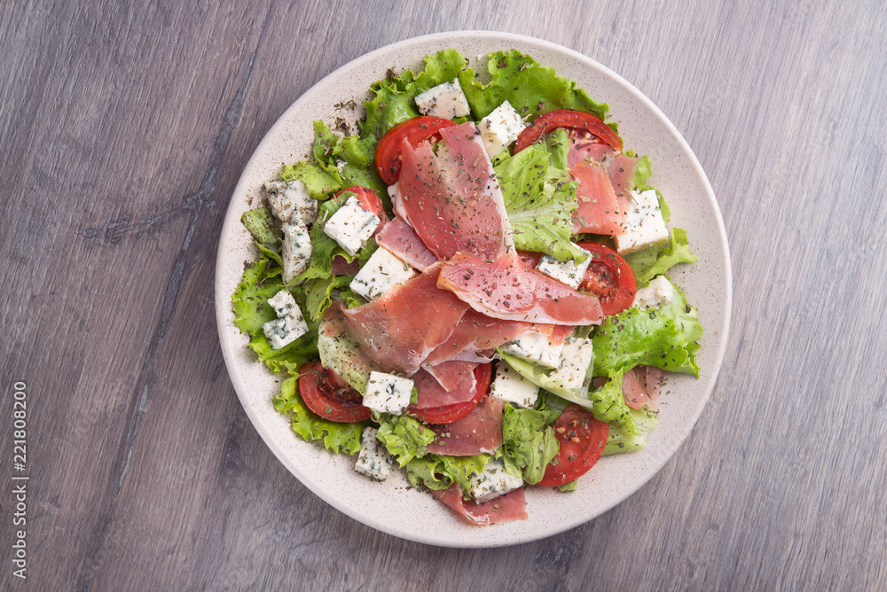 Fresh salad with prosciutto, tomato, lettuce and cheese blue