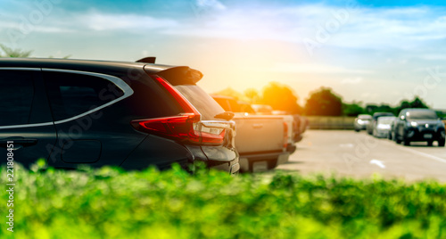 Fototapeta Naklejka Na Ścianę i Meble -  SUV Car parked on concrete parking area at factory near the sea with blue sky and clouds. Car dealership. Car stock for sale. Car factory parking lot. Automotive Industry. Used automobile business.