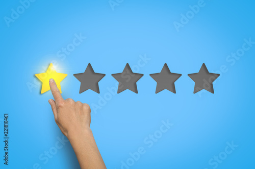 Female hand leaves a rating of one star out of five possible on