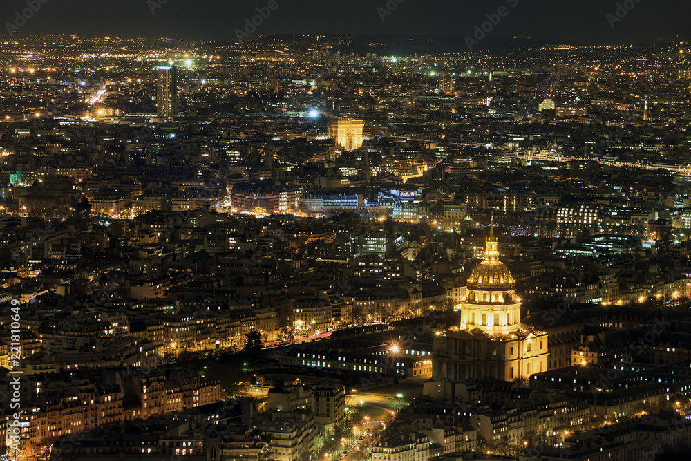 Beautiful aerial cityscape of Paris, France, at night with the Dome des Invalides and the Arc de Triomph