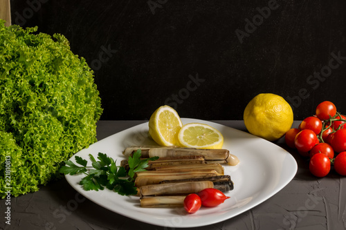 Fresh seafood with parsley and lemon, salad and tomatoes, italian cuisine, grey backgraund and copyspace photo