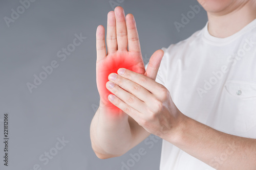 Pain in hand, carpal tunnel syndrome on gray background