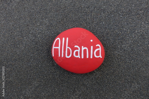 Albania, balkanic eastern Europe country name carved on a red colored stones over black volcanic sand photo