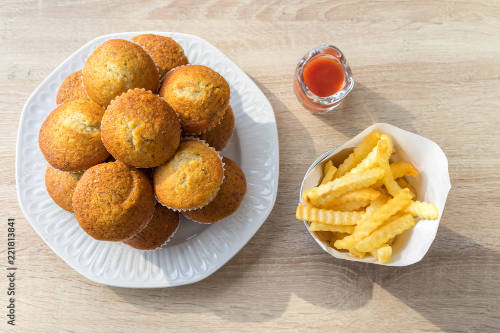 Top of banana muffins, French fries and ketchup on the wood table in the restaurant. Top of banana muffins, French fries and ketchup on the wood table in the restaurant.