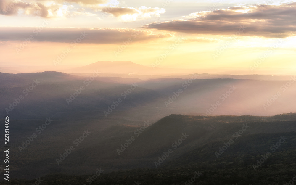 Fog in mountains, fantasy and colorful nature landscape and ray of sunlight through clouds, view from the top view of mountains.  