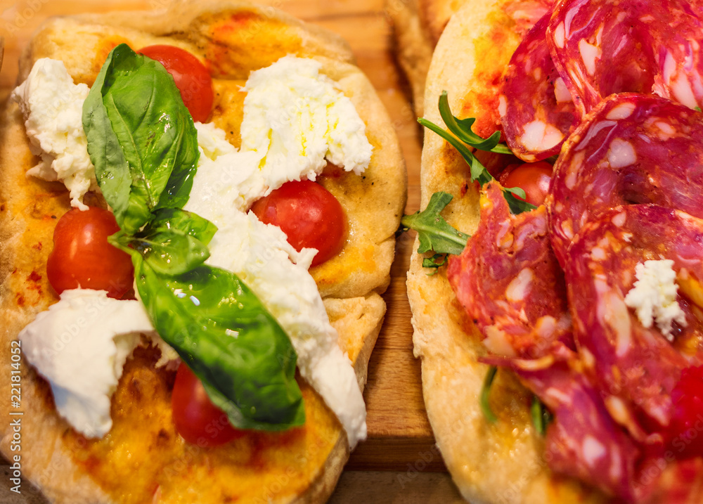 Italian focaccia with Pepperoni, basil leaf and cheese on a rustic wooden table closeup. Pizza Ready to Eat. Top view Italian focaccia with Pepperoni, basil leaf and cheese on a rustic wooden table closeup. Pizza Ready to Eat. Top view