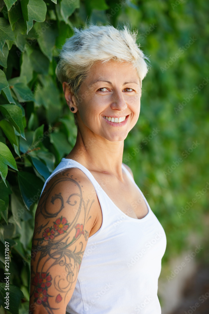 Woman with flowered tattoos on her arm Woman with flowered tattoos on her arm
