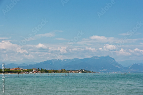 Italy - Lake Garda. Blue waters are lush greenery of Italian nature and the mighty slopes of the Alpine mountains.