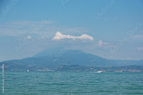 Italy - Lake Garda. Blue waters are lush greenery of Italian nature and the mighty slopes of the Alpine mountains.