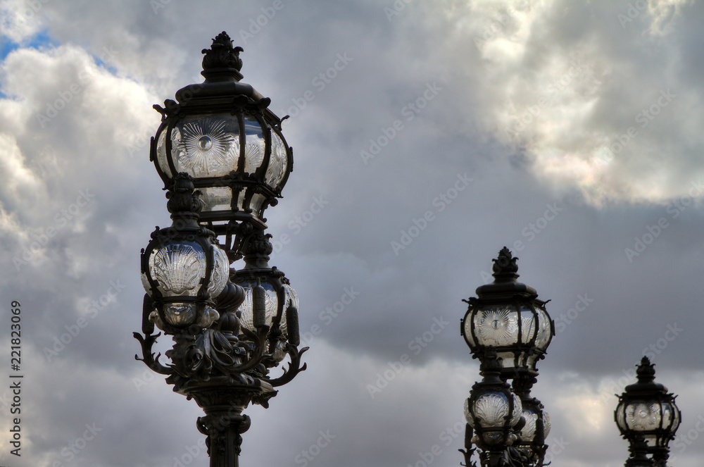 Lanterns on the Pont Alexandre III against a cloudy sky in Paris 